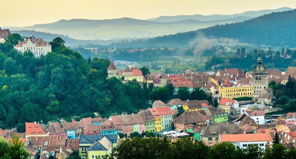 Panorama cetatii Sighisoara, cu Turnul cu Ceas si casele colorate, la apus